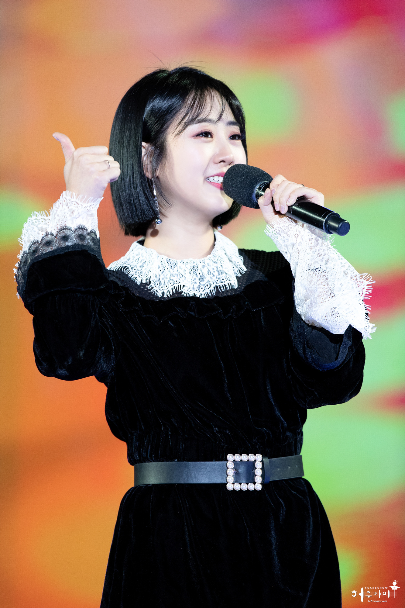 무대에서 마이크를 들고 엄지손가락을 들어 보이는 가수 강혜연